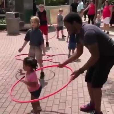 Just a dad helping his daughter with the Hula Hoop.