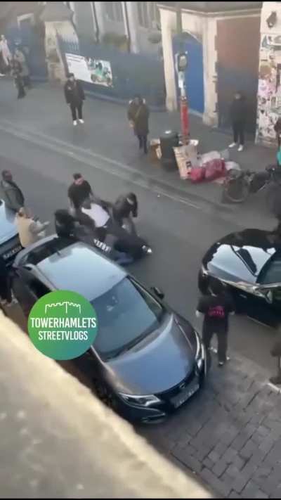 Two men on their way in the wrong direction on Brick Lane in a car knock a motorcyclist over. When he tries to stop them, they beat, attack, and run him over, injuring his legs.