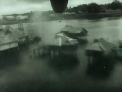 Rear facing camera on a B-25 Mitchell bomber captures the parafrag bombs and gunfire from the tail turret over Japanese targets in the Pacific circa 1943