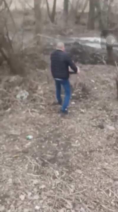 Ukrainian man removing a landmine from the road with his bare hands (Berdyansk, Ukraine)