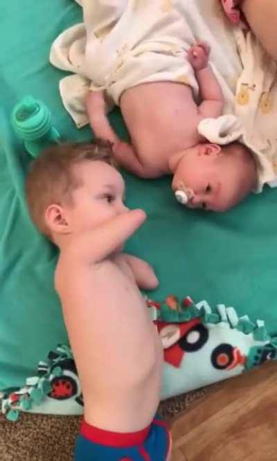 Little kid gives baby brother pacifier