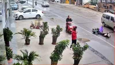 Motorbike rider in China has a seizure and falls. Everyone looks at her seizing on the ground in apathy and just carries on like nothing's happened