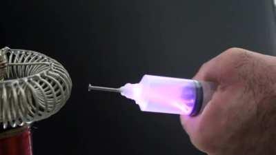 Extracting electricity from a tesla coil using a syringe