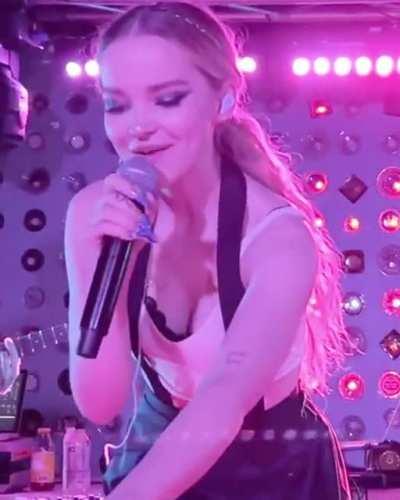 Dove Cameron bending over at her concert