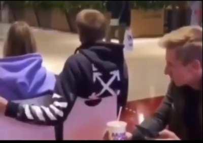 A guy helping out another guy put his arm around a girl