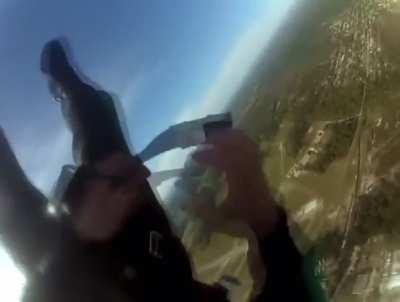 Person keeps their cool while they fix a strap on their parachute late free fall
