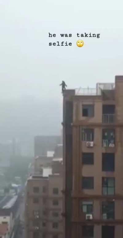 Man taking selfie on roof of high rise building, falls.