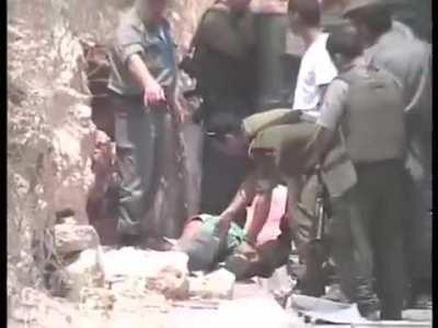 Israeli soldiers shoot a Palestinian captive who was already blindfolded and handcuffed 