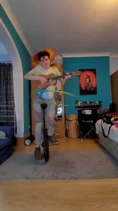 playing Plug in baby by Muse on ukulele whilst hula hooping on a unicycle