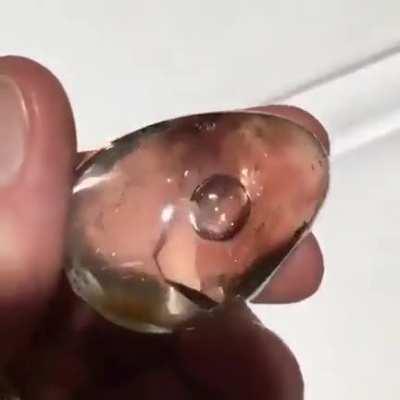 Millions of years ago hot water was trapped inside this crystal as it cooled and contracted... this vapor bubble was formed inside the quartz.