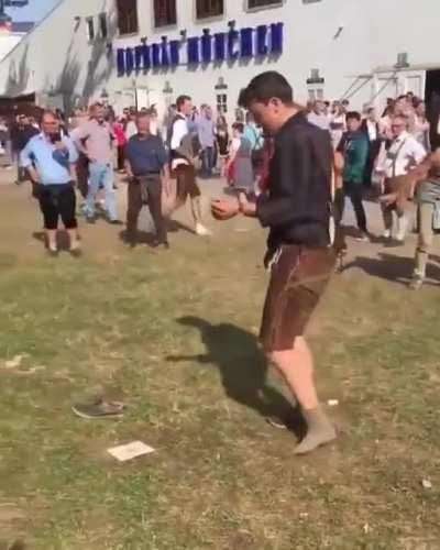 Guy attempting to put on his shoe while crowd cheers him on