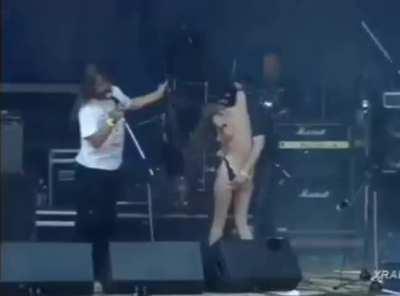 Girl struggles to keep her panties on, has bare ass exposed on stage at concert for all to see