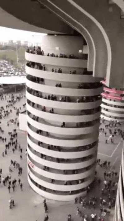 It looks like the whole column is turning but in fact only the people do. The reason for this is that you can't see the moving legs, so the people appear to be standing.