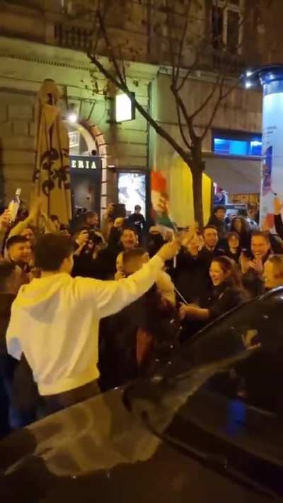 An old lady goes out to celebrate with young people on the streets of Budapest, Hungary