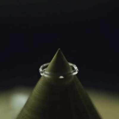 Drop of water falling on a sharp point