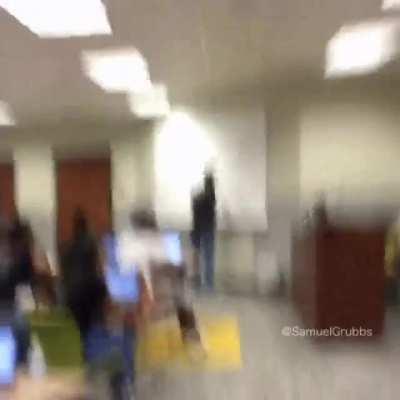 A kid making a no look shot during class.