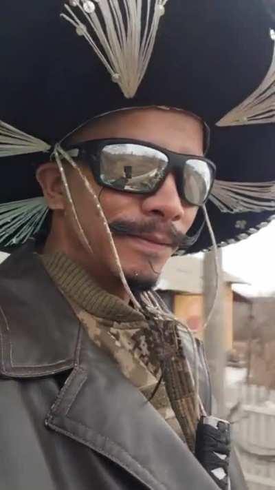 Columbian volunteer fighting for Ukraine riding around in style, with a massive sombrero and a katana in his waist