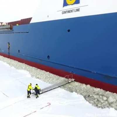 Harbor pilot boarding a ship in icy waters