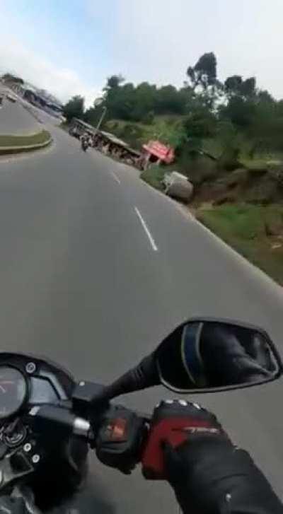 Biker slides underneath a car