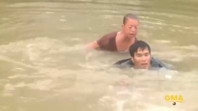 Man successfully rescues a woman and her dog seconds before her car is submerged in a flood