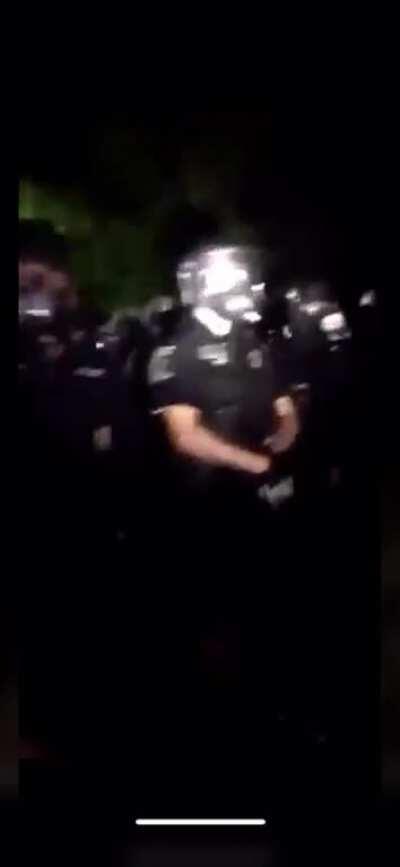 Large group of officers lined up in front of George Floyd killers house