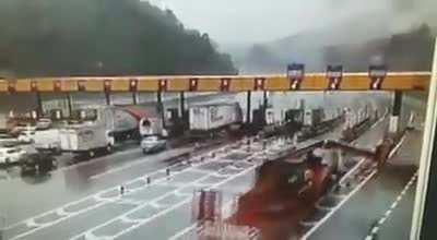 Truck takes out toll booth.