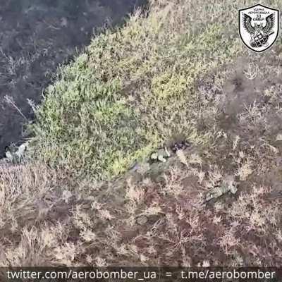 30th Brigade drops explosives on a Russian's leg and show the amount of dead and wounded littering the field. Near Bakhmut. Released November 2023.