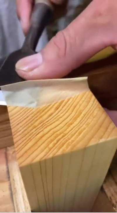 Chiseling a paper thin layer off a wood block