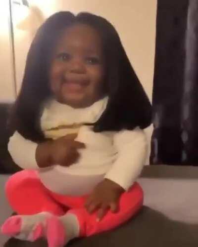 Did not know a baby in a wig would make me smile, but here we are