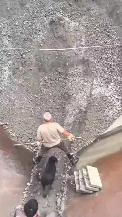 Workers keeping the gravel flowing in a narrow work channel