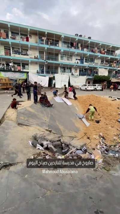 Children in north Gaza playing in the crater left behind in an UNRWA school