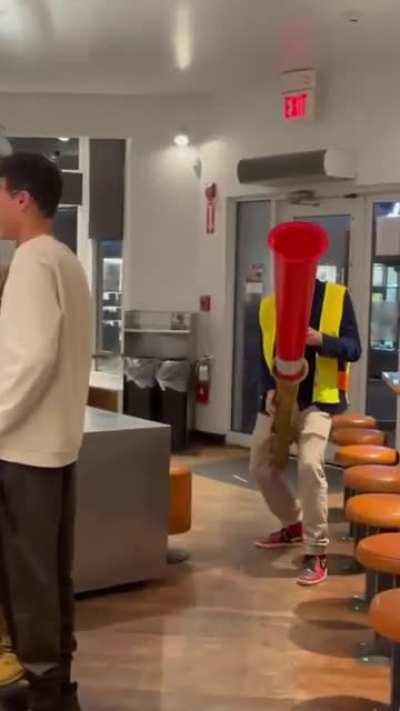 Guy playing a saxophone with traffic cone appendage