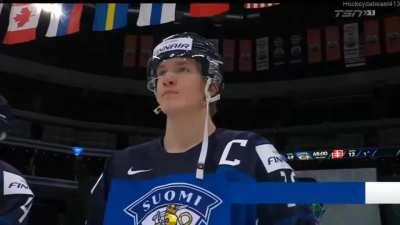 Anton Lundell takes a High Stick from Roni Hirvonen as he's announced as the Player of the Game for Finland.