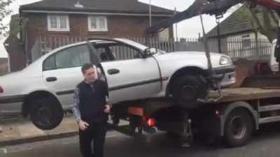 Idiot desperately tries to save car from towing