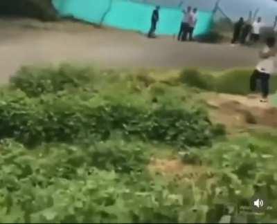 Man stands too close to a dirt bike race track