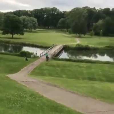 Man lands a hole in one in the lake with his clubs
