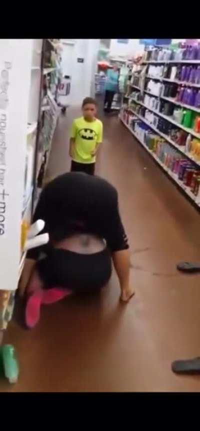 A child with his mother is fighting with a woman who works in a supermarket.