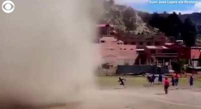 A dust devil interrupts a football match in Bolivia
