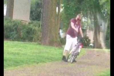 Drunk man mounting a bike