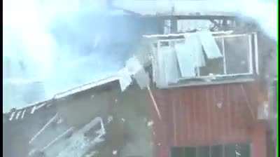 Idiot standing on top of a exploding building.