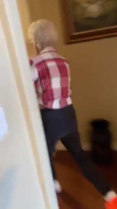 Grandma plays along with grandson with a nerfgun