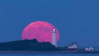 Rare blood-red full moon rise above Boston Light. [babaktafreshi]