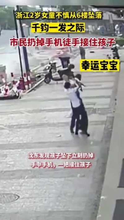 Unknown hero agent man catches a 2-year-old girl who fell from a 5th floor window. Toddler saved by terrace yet suffered broken arms.