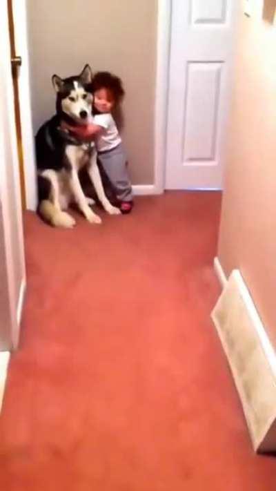 Criança com medo de aspirador busca proteção com o cachorro.