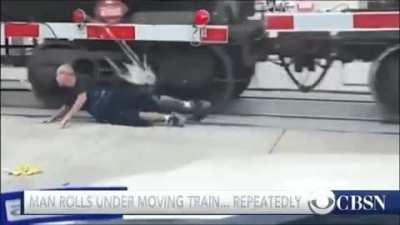 Man rolls under a moving train... repeatedly