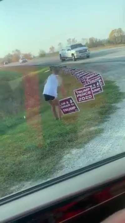 A woman removing all trump signs