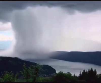 Cloudburst of rain onto a river