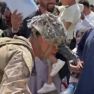 US Marine shares water with children waiting to be granted access at Afghan airport. Via: ChugForVets