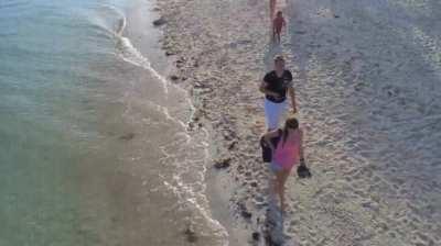 Boy is fascinated by a quadcopter on the beach
