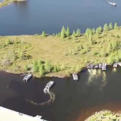 Boat owners moving a large floating island out of the way on Wisconsin's Lake Chippewa